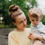 Young mother with little son on together walk after work day.